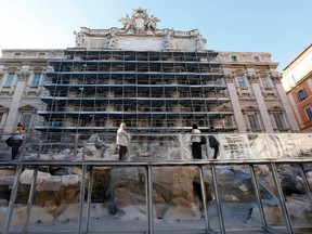 Tourists stand on a specially built footbridge in front of the famed Trevi Fountain in Rome June 30, 2014. (REUTERS/Remo Casilli)