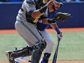 Milwaukee Brewers catcher Martin Maldonado pushes past Blue Jays left fielder Darin Mastroianni as he fields a bunted ball to begin a double play in the seventh inning at Rogers Centre on Wednesday afternoon. (Dan Hamilton/USA TODAY Sports)