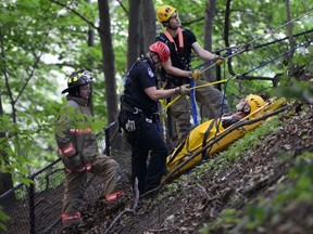 Hamilton Fire hauled a man and his motorized scooter up the hillside behind Dundurn Castle after getting calls about a man falling over the edge. (ANDREW COLLINS/Special to the Toronto Sun)
