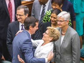 Ontario Premier Kathleen Wynne  embraces former premier Dalton McGuinty in the legislature after the throne speech on July 3, 2014. (Ernest Doroszuk/Toronto Sun)