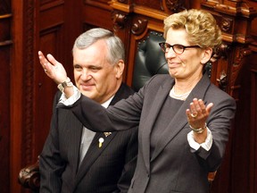 Ontario Premier Kathleen Wynne gestures after being sworn in as the 25th premier of Ontario, next to Ontario Lieutenant Governor David Onley at Queen's Park on Tuesday.