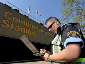 City Patrol Officer Karrie MacDonald, with Parking Enforcement Services, poses for a photo at Commonwealth Stadium, in Edmonton Alta., on Thursday July 3, 2014. The City of Edmonton is reminding motorists that it will be stepping up parking enforcement during special events being held in and around Commonwealth Stadium. David Bloom/Edmonton Sun