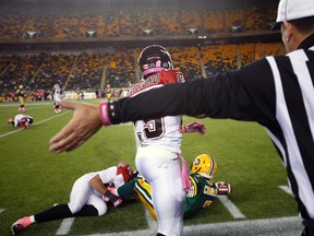 Edmonton Eskimos runningback Hugh Charles is declared safe by a referee after a tackle by Calgary Stampeders linebacker Juwan Simpson during the second half at Commonwealth Stadium in the Eskimos final home game of the 2013 season. (Ian Kucerak, Edmonton Sun)