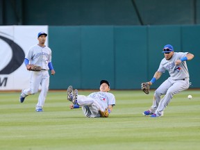 Blue Jays second baseman Munenori Kawasaki (66) is unable to control the ball between centre fielder Anthony Gose (8) and right fielder Melky Cabrera (53) during fifth inning MLB action against the Athletics in Oakland on Thursday, July 3, 2014. (Kelley L Cox/USA TODAY Sports)
