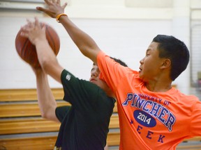 Ethan Choi moves to block a Newell County player in the gold medla game for 3-on-3 boys basketball in St. Mike's gym at the SASG 2014. John Stoesser photo/QMI Agency