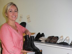 Susan Chamberlain, of The Book Keeper, shows off some of the shoes recovered from Mister Fix It in need of their owners. Chamberlain has been trying to reunite an assortment of shoes, backpacks and other goods to their rightful owners after the neighbouring shoe repair store closed unexpectedly last summer. BARBARA SIMPSON/THE OBSERVER/QMI AGENCY