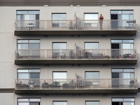 A downtown resident looks out over the city from her balcony in London. DEREK RUTTAN/ The London Free Press /QMI AGENCY