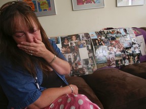 Jenny Parker sits on her couch with two collages of pictures of her son Douglas who was gunned down in a shooting that left three of his friends wounded on May 24 at a housing complex on Walpole Ave., near Gerrard and Greenwood. (Jack Boland/Toronto Sun)