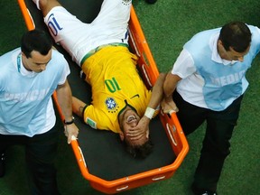 Brazil's Neymar grimaces as he is carried off the pitch after being injured during their 2014 World Cup quarter-finals against Colombia at the Castelao arena in Fortaleza July 4, 2014. (REUTERS/Fabrizio Bensch)