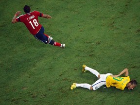 Brazil's Neymar grimaces as he lies on the ground injured after a challenge by Colombia's Camilo Zuniga during their 2014 World Cup quarter-finals at the Castelao arena in Fortaleza July 4, 2014. (REUTERS/Fabrizio Bensch)