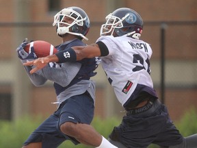 Linebacker Antwuan Molden (right), one of five new faces on defence from last week’s opener, tries to break up a pass intended for Jason Barnes during an Argos practice. (Jack Boland, Toronto Sun