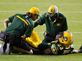 Edmonton's Marcell Young (23) is looked at by trainers after being injured during the Edmonton Eskimos' CFL football game against the Hamilton Tiger-Cats at Commonwealth Stadium in Edmonton, Alta., on Friday, July 4, 2014. The Eskimos won 28-24. Codie McLachlan/Edmonton Sun/QMI Agency