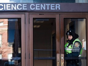 A police officer looks out of an entrance to the Science Center at Harvard University in Cambridge, Mass., in this Dec. 16, 2013 file photo. REUTERS/Dominick Reuter