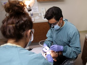 University of Alberta fourth-year dental student Robert Kurio works on a patient at the SHINE (Student Health Initiative for the Needs of Edmonton) Dental Clinic at the Boyle MacCauley Health Centre  in Edmonton, AB on Saturday, July 5, 2014. The SHINE clinic is in its ninth year of operations and offers much-needed dental services to Edmonton's inner-city population at no cost to the patient. Trevor Robb/Edmonton Sun/QMI Agency