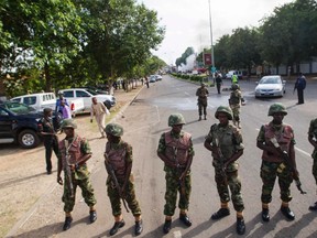 Nigerian army soldiers stand guard as they cordon off a road leading to the scene of a blast at a business district in Abuja in this June 25, 2014 file photo. (REUTERS/Afolabi Sotunde)