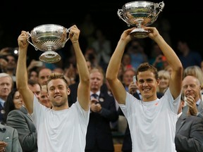 Vasek Pospisil of Canada and Jack Sock of the U.S. (L) hold their winners trophies after defeating Bob Bryan of the U.S. and Mike Bryan of the U.S. in their men's doubles final tennis match at the Wimbledon Tennis Championships, in London July 5, 2014.            REUTERS/Suzanne Plunkett