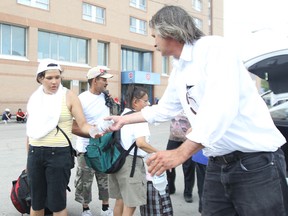 Ron Eldridge of Devoted to You Street Ministries hands out bottled water to homeless people.