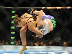 Ronda Rousey (red gloves) takes down Alexis Davis (blue gloves) during the first round of a bantamweight fight at Mandalay Bay Events Center on Jul 5, 2014 in Las Vegas, NV, USA. (Stephen R. Sylvanie/USA TODAY Sports)