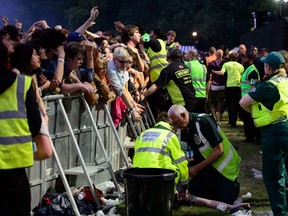 Medical teams help people from the crowd when people begin to be crushed as British group The Libertines perform onstage at the British Summer Time festival in Hyde Park in central London, on July 5, 2014. (AFP PHOTO/Leon Neal)
