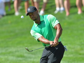 Tiger Woods chips onto the green on the 15th hole during the first round of the Quicken Loans National in Bethesda, Md., last month. (Tommy Gilligan/USA TODAY Sports)