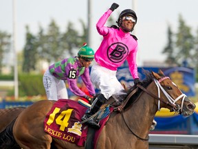 Jockey Patrick Husbands celebrates as he crosses the finish line ahead of Ami's Holiday to win the 115th Queen's plate on Sunday at Woodbine Racetrack. (Michael Burns photo)