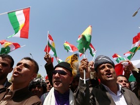 Iraqi Kurdish protesters wave flags of their autonomous Kurdistan region during a demonstration to claim for its independence on July 3 outside the Kurdistan parliament building in Arbil, in northern Iraq. The Kurdish leader, Massud Barzani asked its parliament to start organizing a referendum on independence. (Safin Hamed/AFP PHOTO)