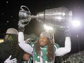 Saskatchewan Roughriders Dwight Anderson hoists the Grey Cup after beating the Hamilton Tiger-Cats in the 101st CFL Grey Cup in Regina, Sask., on Sunday November 24, 2013. Lyle Aspinall/QMI Agency