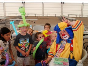 Children make balloon animals with Slappy the clown during Kenora Arts Project Street Fest events on Saturday, July 5.