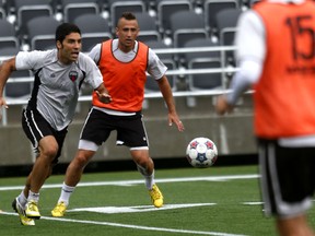 Ottawa Fury FC defenders Ramon Soria and Maykon eye the ball Monday during the team's first-ever training session at TD Place. (Chris Hofley/Ottawa Sun)​