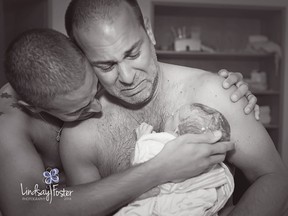 Fathers Frankie Nelson, left, and BJ Barone cuddle their newborn son Milo after a surrogate mother gave birth to him on June 27.