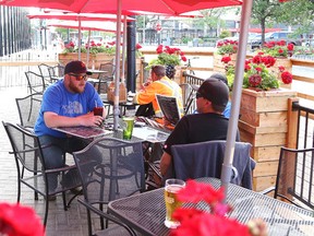 Gino Donato/The Sudbury Star   
Customers enjoy some food and drinks at the Peddlers Pub patio on Cedar Street on Monday afternoon.