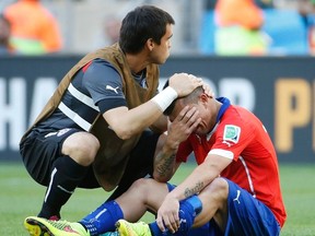 Chile's Gary Medel (right) is comforted by goalkeeper Johnny Herrera after losing their World Cup Round of 16 game against Brazil at the Mineirao stadium in Belo Horizonte, Brazil on June 28, 2014. (Eric Gaillard/Reuters)
