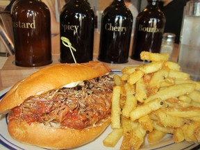 Meat’s pulled pork sandwich with garlic fries, backed by the restaurant’s four proprietary table sauces.