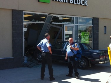 A car is seen after crashing into the front window of an H&R Block location at the Grant Park Mall in Winnipeg, Manitoba, Canada, Tuesday, July 8, 2014.