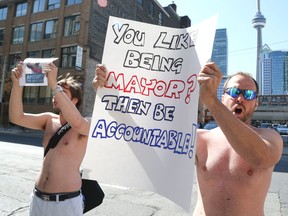 Shirtless protesters targeted Mayor Rob Ford on Richmond St., behind News Talk 1010, where the civic leader was interviewed on July 4, 2014. (VERONICA HENRI, Toronto Sun)