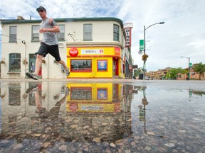 A man is reflected in a puddle, along with the Prince Albert?s Diner, as he jogs his way down Richmond St. in London Tuesday. (CRAIG GLOVER, The London Free Press)