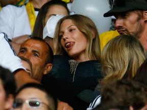 A photo shows Sarah Brandner, the girlfriend of Germany's Bastian Schweinsteiger, holding balloons before putting them under her shirt while waiting for the start of the 2014 World Cup semi-finals between Brazil and Germany at the Mineirao stadium in Belo Horizonte July 8, 2014. (REUTERS/Kai Pfaffenbach)