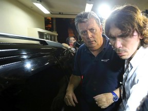 Ray Whelan (L), of Switzerland-based Match Services, arrives at a police station after being arrested in Rio de Janeiro July 7, 2014. (REUTERS/Stringer)