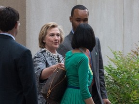 Former US Secretary of State Hillary Clinton speaks with aide Huma Abedin as she leaves Lisner Auditorium at the George Washington University after speaking about her new book "Hard Choices" in Washington on June 13, 2014. AFP PHOTO/Nicholas KAMM