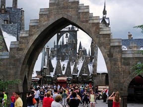 Guests walk in and out of Hogsmeade Village during a media preview for The Wizarding World of Harry Potter-Diagon Alley at the Universal Orlando Resort in Orlando, Florida June 19, 2014. The new attraction, which opens to the public on July 8, expands the original Harry Potter world, which opened in 2010 and is modeled after Hogsmeade Village, which is located near the Hogwarts School of Witchcraft and Wizardry where the series' leading character Harry Potter begins his magical adventures. REUTERS/David Manning