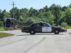 OPP remains at the scene on Saturday where  burned vehicle was found early Friday morning with three bodies inside on Holick Road, north of the 4th Line of Oro-Medonte Township, just north of Barrie. OPP say the deaths are suspicious.
ZACH MACPHERSON/BARRIE EXAMINER/QMI Agency Photo