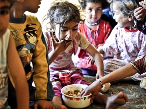 Syrian children eat lunch in a disused house on June 28, 2014 in the Fikirtepe area of Istanbul. Hundreds of Syrian refugees live in empty houses in an area of 32 hectares undergoing an urban transformation project in Fikirtepe, which is on standby due to ongoing negotiations between the owners of the houses and the company running the project.  AFP PHOTO / OZAN KOSE
