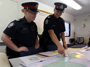 Edmonton Police Service (EPS) Northeast Division acting sergeant Keith Pitzel, right, and acting staff sergeant KIm Clark go over strategy inside the EPS Mobile Action Centre at Abbottsfield Mall in Edmonton, AB on July 9, 2014. The officer's were on scene as part of the EPS Community Action Team (ACT). Trevor Robb/Edmonton Sun