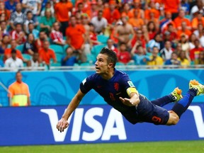 Robin van Persie of the Netherlands heads to score against Spain during their 2014 World Cup Group B soccer match at the Fonte Nova arena in Salvador June 13, 2014. (REUTERS/Michael Dalder)