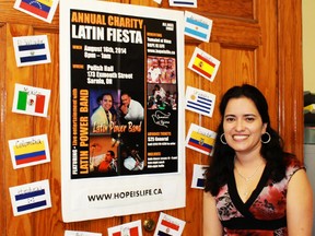 Nayi Rincon, chair of the Catholic Hispanic Community of Sarnia-Lambton stands beside a poster advertising the group's annual Charity Latin Fiesta. The Fiesta takes place on Aug.16 and features music, dancing and a selection of Latin American food, with all proceeds supporting Tumaini ni Uzima (Hope is Life), a charity that supports exploited women in Congo.