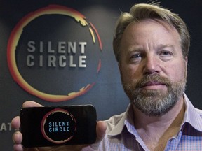 Mike Janke, CEO and co-founder of Silent Circle, makers of encrypted communications providing secure multiplatform communication services for mobile devices, desktop and e-mail, holds a typical smartphone similar in styling to a new encrypted smartphone called, "The Blackphone",  Silent Circle will be selling soon, seen here, January 16, 2014, at his National Harbor, Md. office.   (AFP PHOTO/Paul J. Richards)