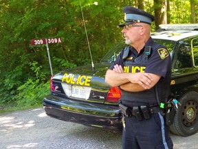 Northumberland OPP Constable Steve Bates watches the driveway leading to a Cranberry Lake Road property on which a cougar has been spotted. (PETE FISHER/QMI Agency)