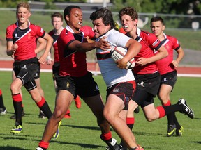Belleville U18 Bulldogs' Ty Shemko tries to fight off a member of the Bristol Cathedral Choir School side during an international rugby match Thursday at M.A. Sills Park. The Bulldogs held on for a slim 26-25 victory. TIM MEEKS/THE INTELLIGENCER