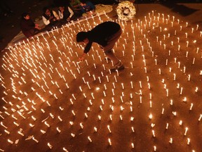 A protester lights candles during a candlelight vigil to mark the first anniversary of the Delhi gang rape, in New Delhi in this December 16, 2013 file photo. (REUTERS/Adnan Abidi)