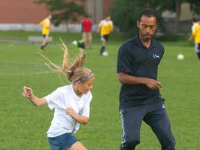 Coach Jose (Garrincha) Figueiredo works with Hailey Burke during a practice for the AG London under-12 girls? team on Wednesday. (Mike Hensen/The London Free Press)